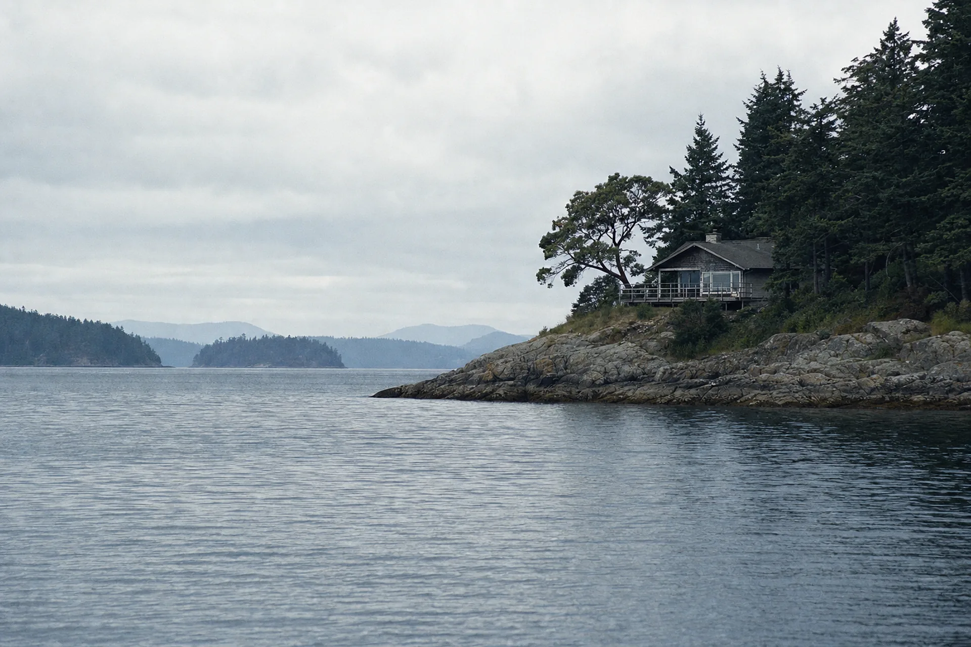 Low afternoon light across the harbor, the raking light that shows every streak and salt mark on west-facing glass